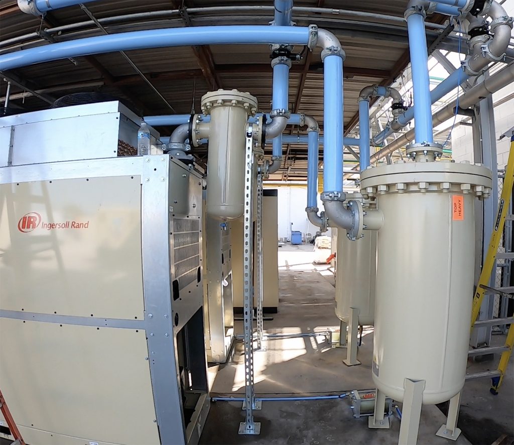 Industrial air compressor system with connected filtration units in an Arle Compressors of Florida facility.